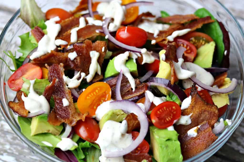 BLT Avocado salad in a glass bowl, topped with ranch dressing 