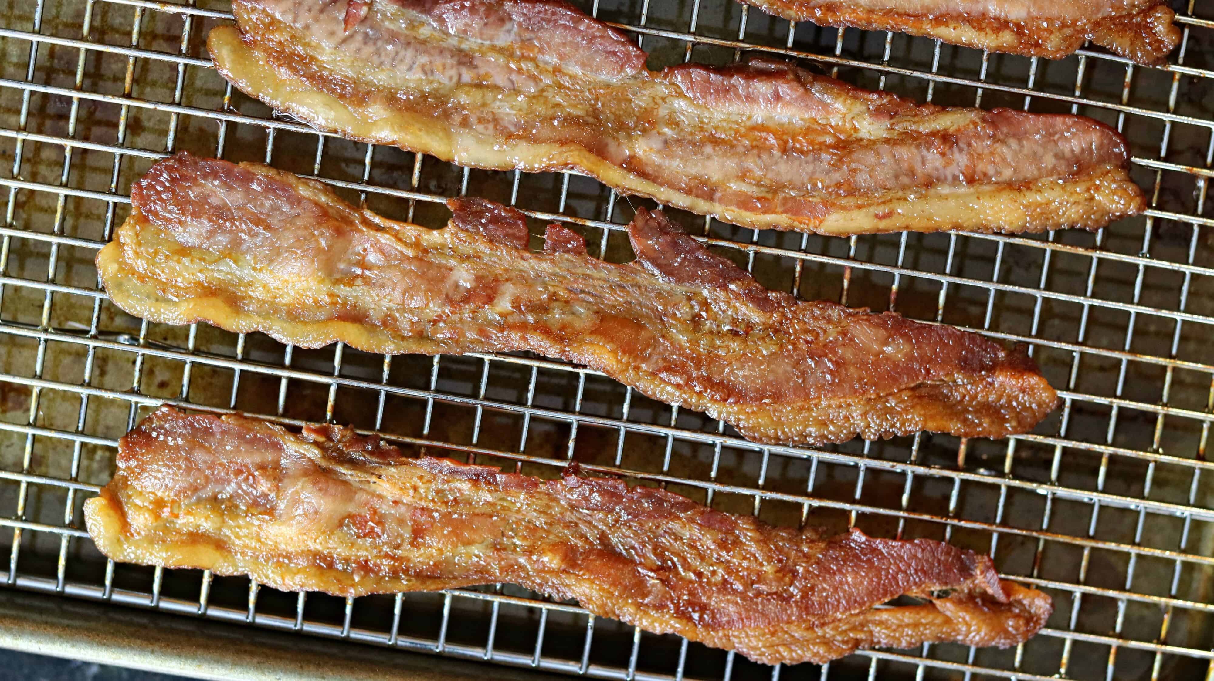 Slices of cooked bacon on a baking sheet