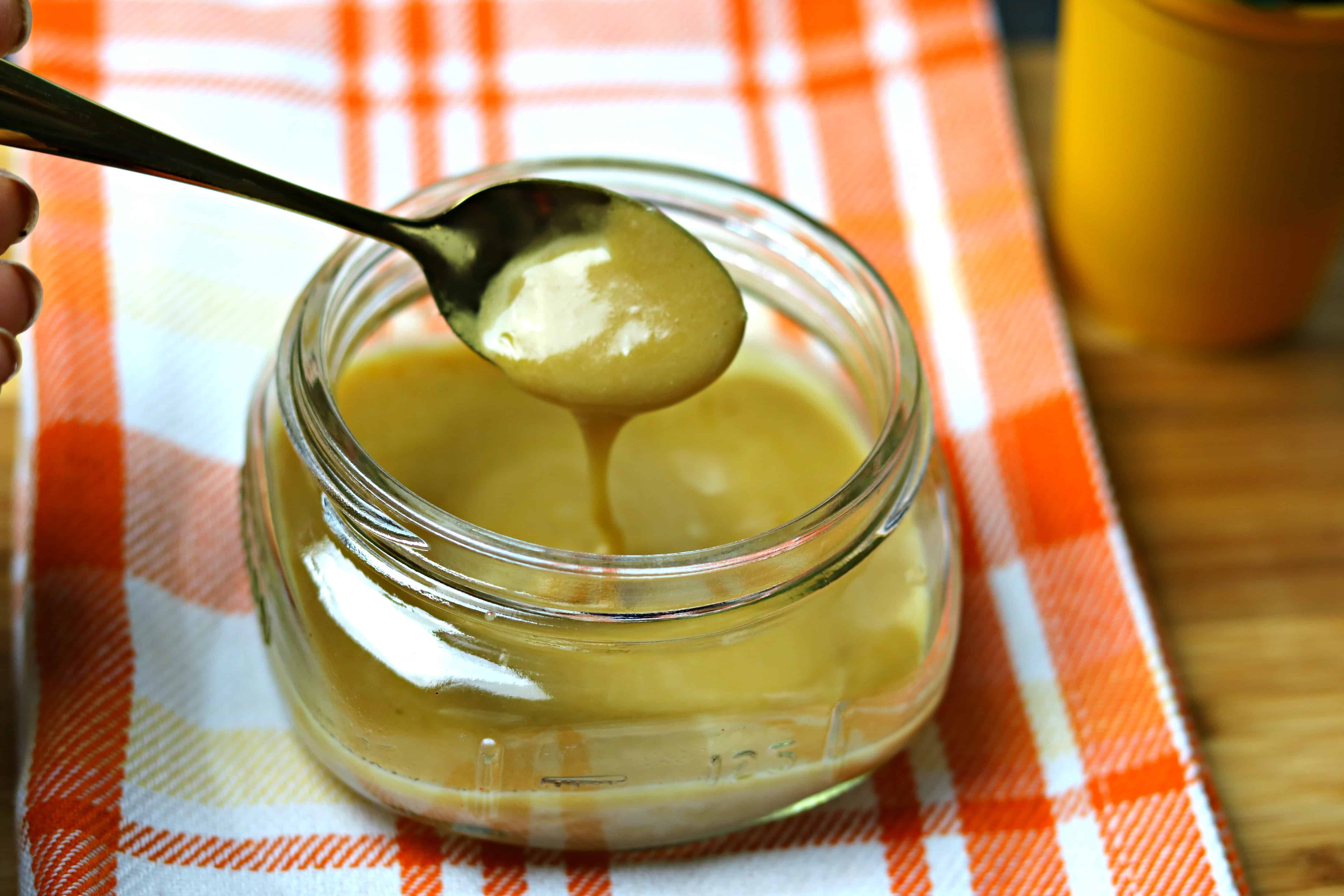 A glass jar full of Keto Browned Butter Salted Caramel with a spoon