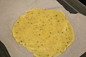 A close up of keto fathead dough that's been flattened with a rolling pin