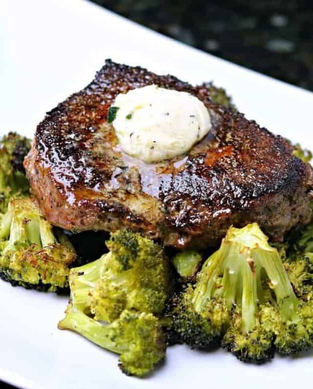Ranch spiced steaks on top of a bed of broccoli on a white serving dish