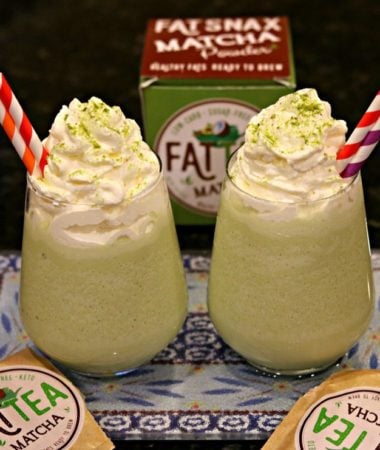 Two glasses of Keto Matcha (Green Tea) Creme Frappuccinos with red and white straws, and surrounded by Fat Snax products