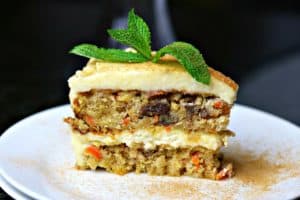 Double layer Low Carb Carrot Cake on a white plate with a mint leaf on top