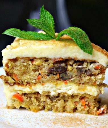 Double layer Low Carb Carrot Cake on a white plate with a mint leaf on top