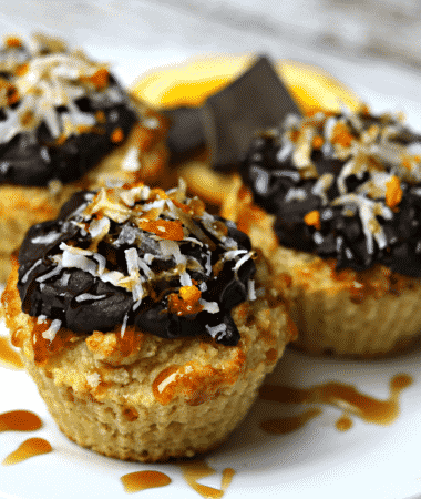 Three Keto Orange Muffins with Orange Chocolate Glaze on a white plate