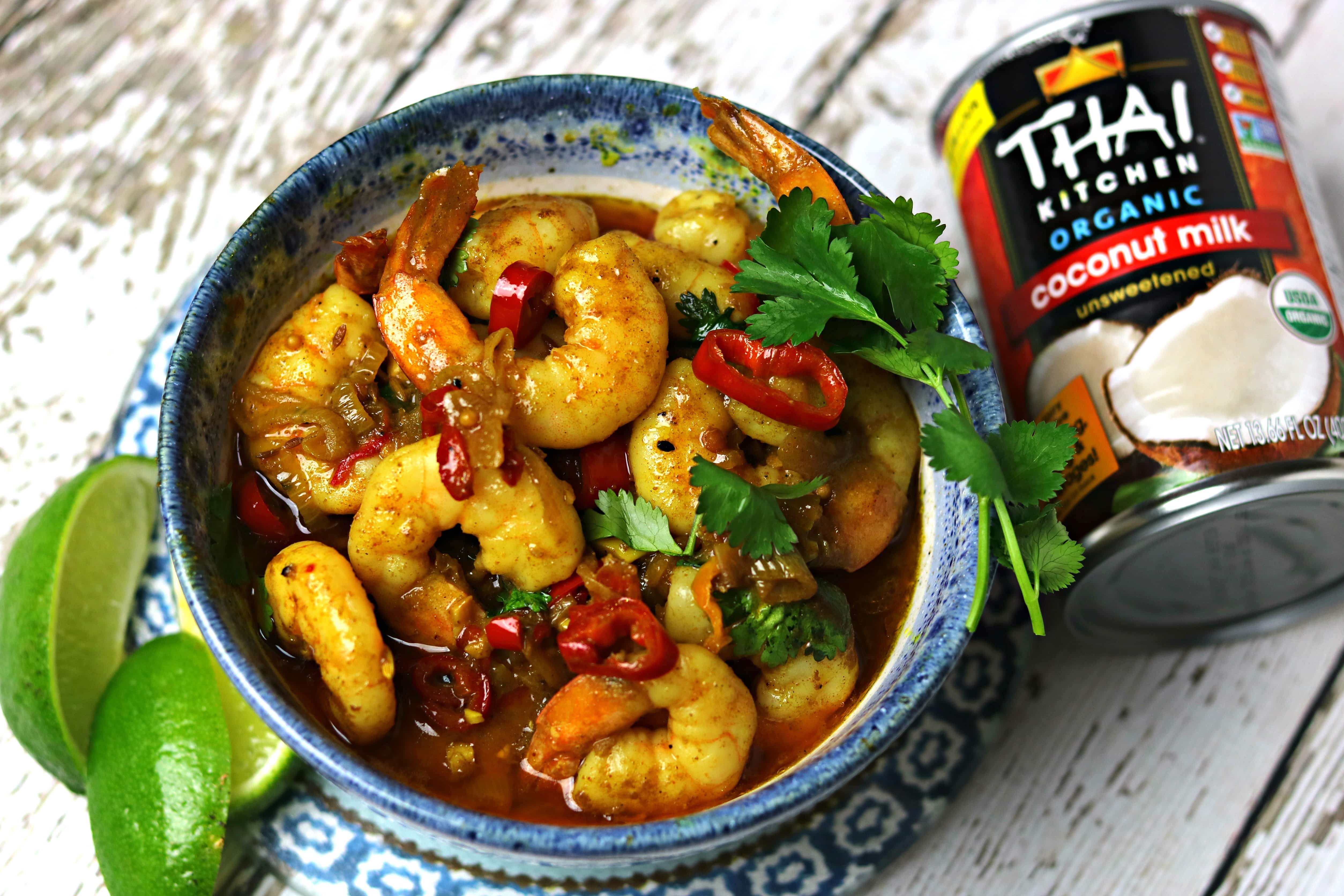 Indian Shrimp Curry recipe in a bowl with limes and coconut milk next to it
