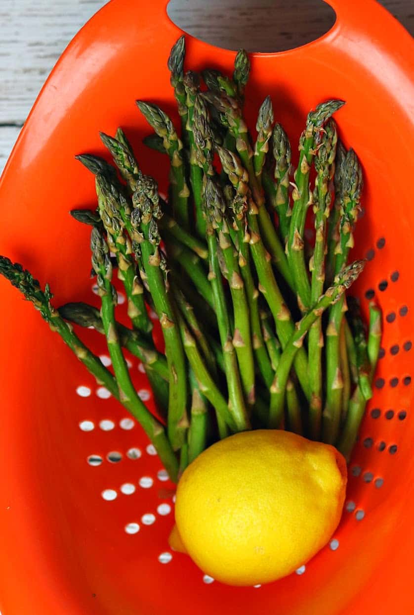 Asparagus in a colander with a lemon