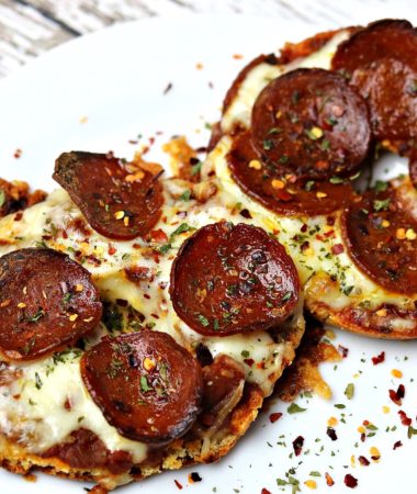 Two keto and low-carb pizza halves sitting on a white plate
