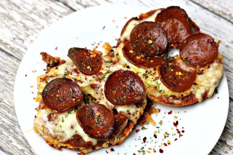 Two keto and low-carb pizza halves sitting on a white plate