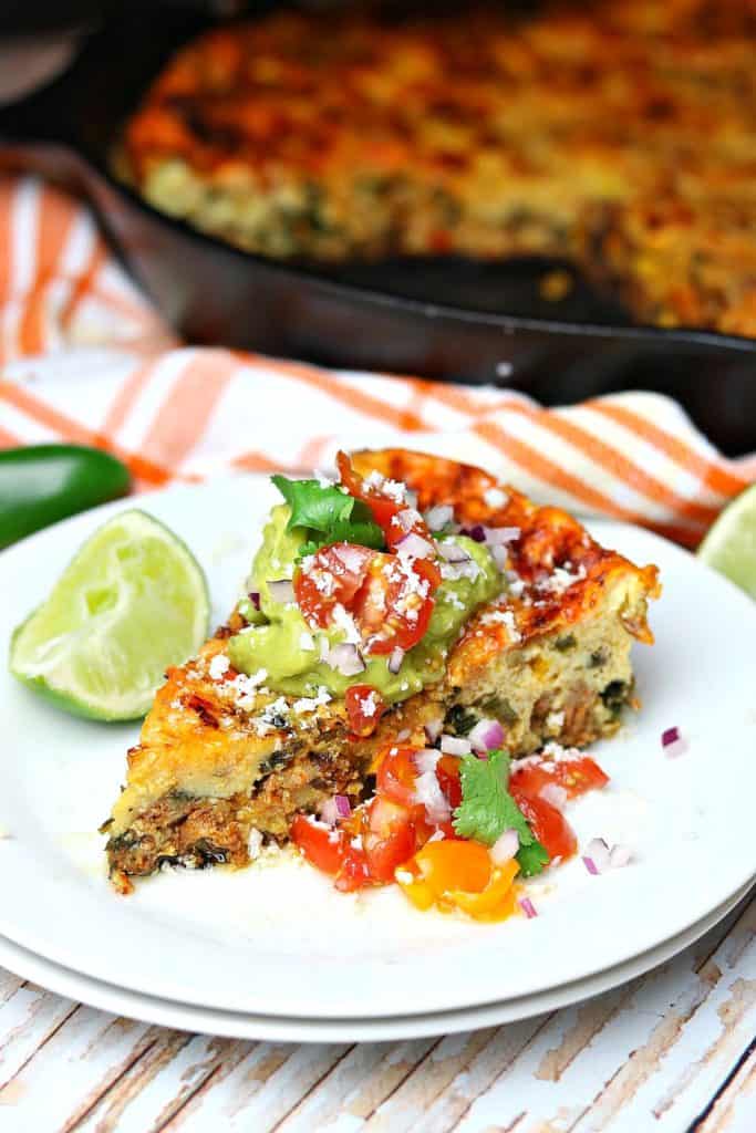 Baked Mexican Frittata on a plate with lime, salsa, and other toppings