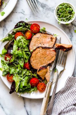 Grilled Cumin Spiced Pork Tenderloin on a plate with a salad