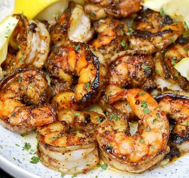close-up of pan-seared shrimp in a bowl with lemons