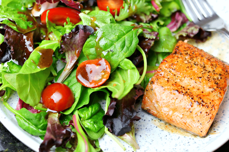 Salad with low-carb Balsamic Vinaigrette on a plate with salmon