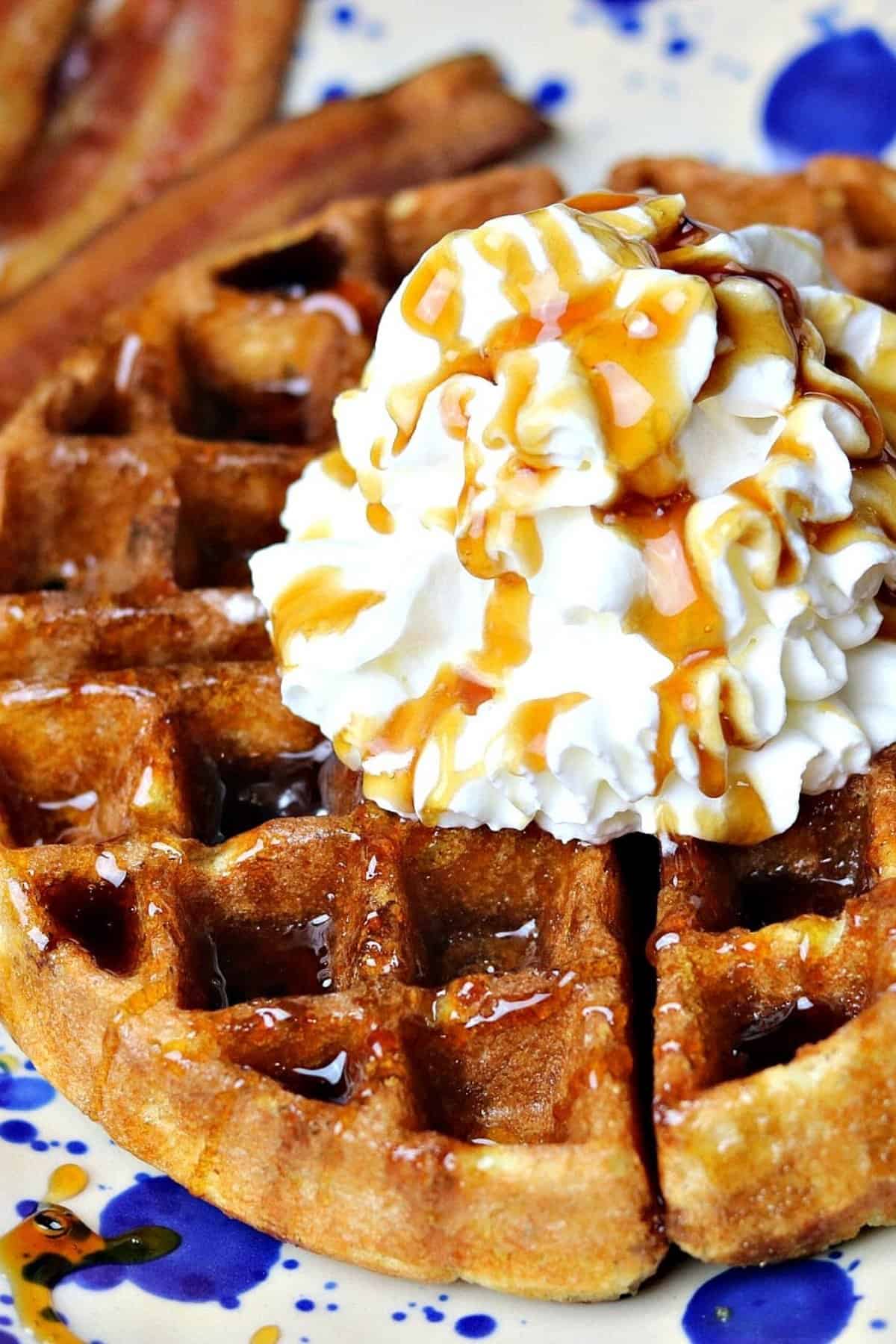 keto waffles on a plate topped with whipped cream