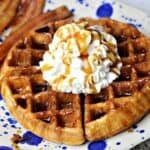 keto waffles on a plate with sugar free whipped cream and bacon
