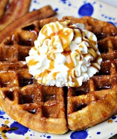 keto waffles on a plate with sugar free whipped cream and bacon