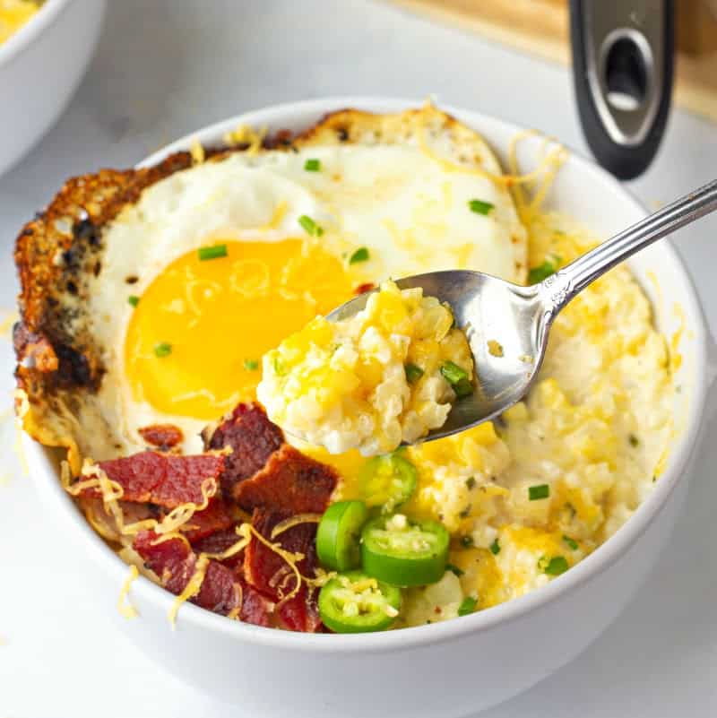 A bowl of food with Cheesy Cauliflower, an egg, jalapeño, and crispy bacon