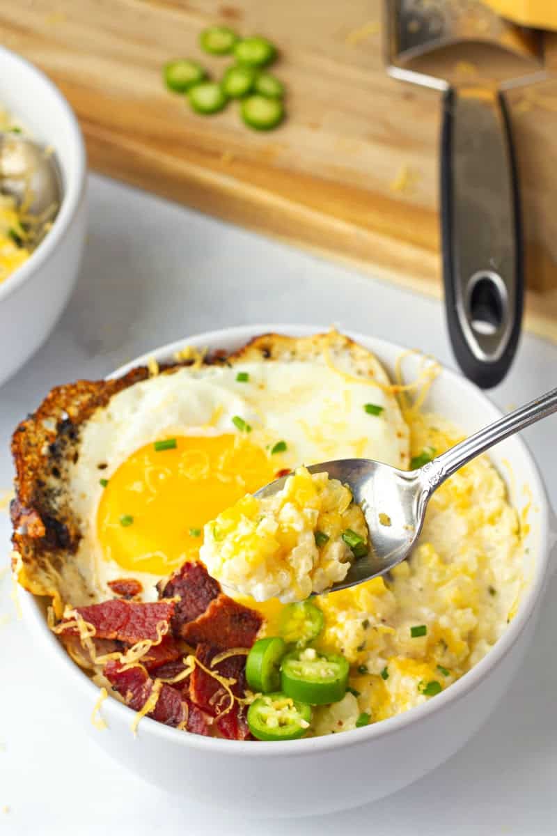 Cheese Cauliflower Rice Grits in a bowl with bacon and jalapeño