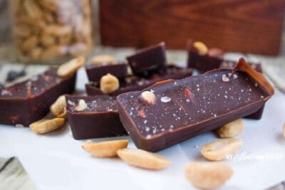 Chocolate peanut low carb candy bar on a white plate with peanuts