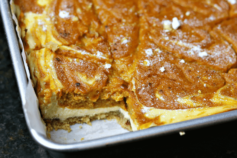 Pumpkin Bars in a square pan with a slice cut out