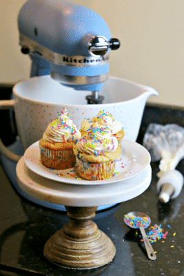 Three Keto cupcakes on a stand with a KitchenAid stand mixer 
