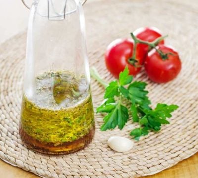 Italian Dressing in a carafe with tomatoes