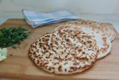 Three pieces of coconut flatbread on cutting board