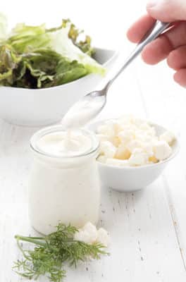 Keto Feta Dressing on table with salad and cheese
