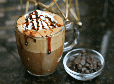 Keto Hot Chocolate in a glass mug next to a small bowl of chocolate chips