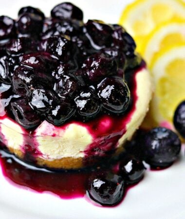 Lemon Blueberry Cheesecake Bites on a white plate with lemon slices