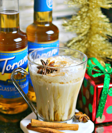 Keto Chai Tea Latte Drink recipe on a coaster with cinnamon sticks