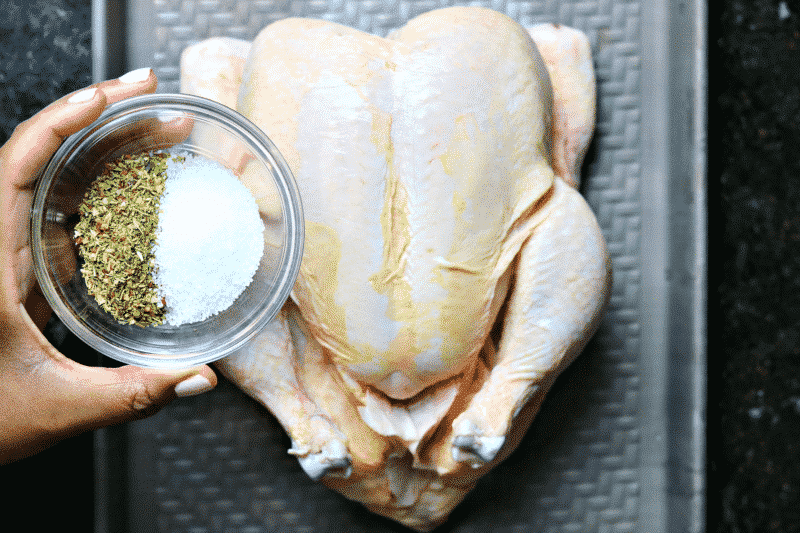 Whole Chicken being seasoned with spices