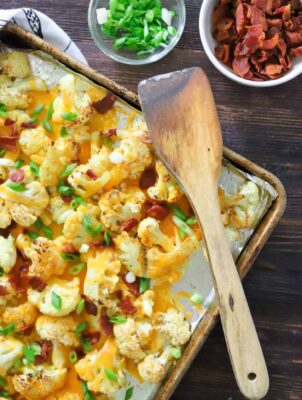 Loaded Cauliflower with bacon and green onions on a sheet pan