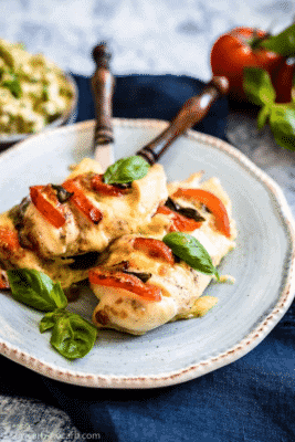 Stuffed Caprese Chicken Hasselback on a light blue serving dish