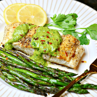 Halibut on a plate with asparagus and chimichurri sauce