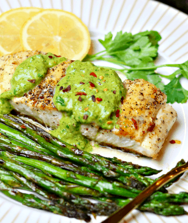 Halibut on a plate with asparagus and chimichurri sauce