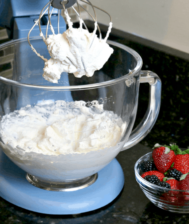 Keto Whipped Cream in a mixer bowl with berries