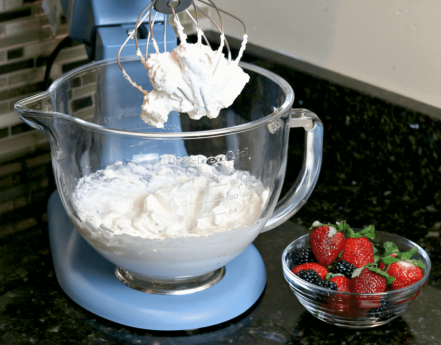 Keto Whipped Cream in a mixer bowl with berries