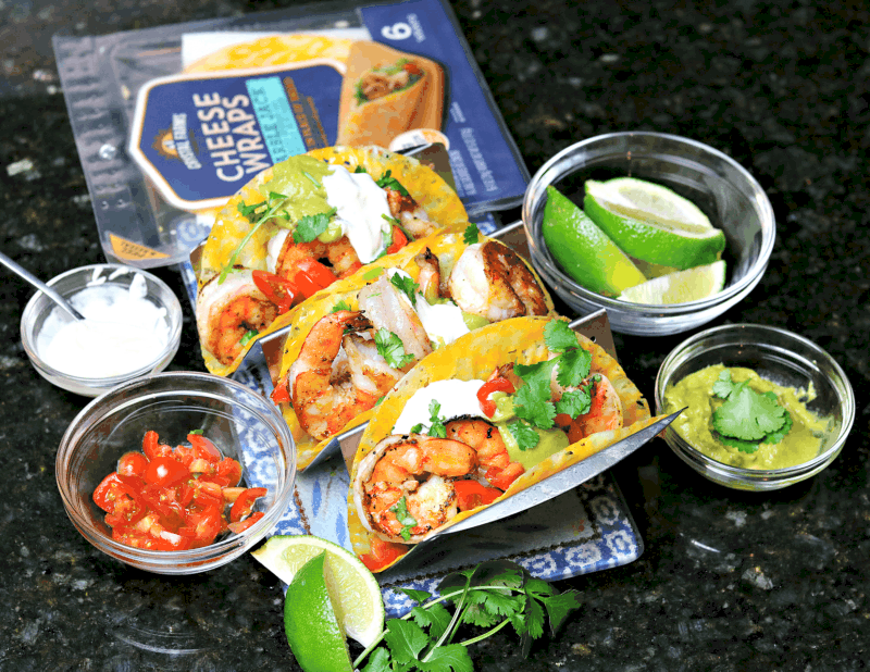 Three shrimp tacos with toppings, and a pack of Crystal Farms Cheese Wraps