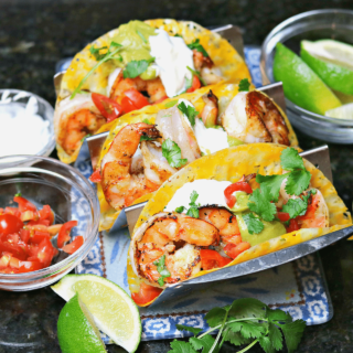 three shrimp tacos on a taco stand