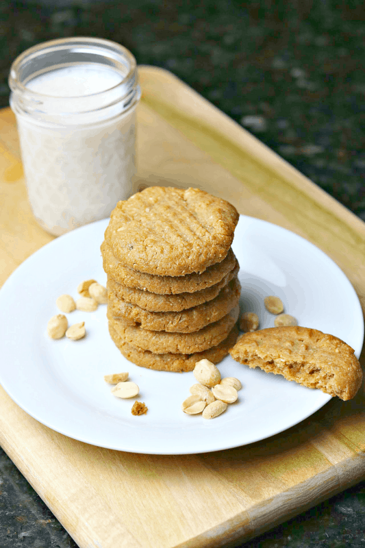 Low-carb peanut butter cookies stacked on a plate with almond milk