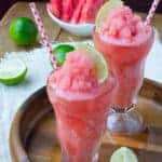 Two glasses of Low-Carb Watermelon Lime Slushies on a wooden serving dish