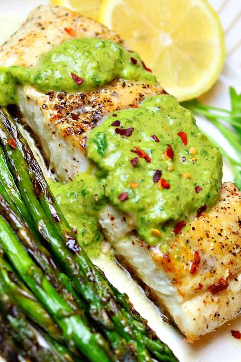 a servings of cast iron halibut on a plate with asparagus