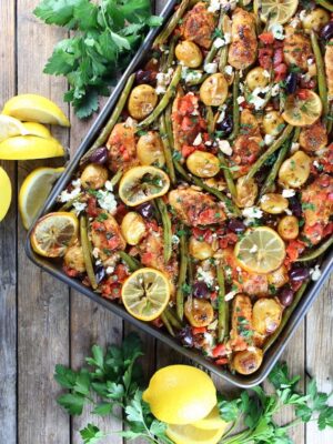 greek chicken on a sheet pan with lemon, herbs and vegetables