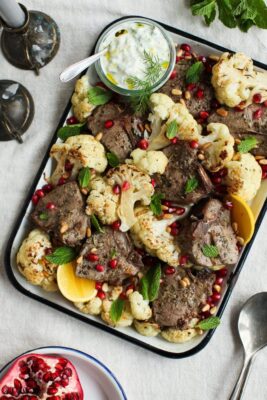 lamb chops and cauliflower on a sheet pan with lemons and herbs
