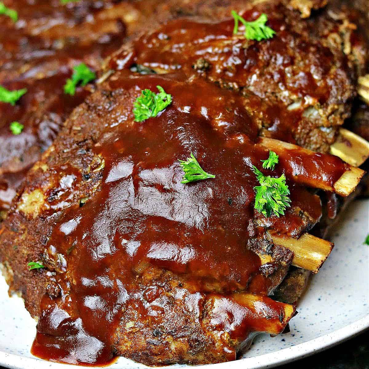 keto ribs on a plate with bbq sauce and parsley