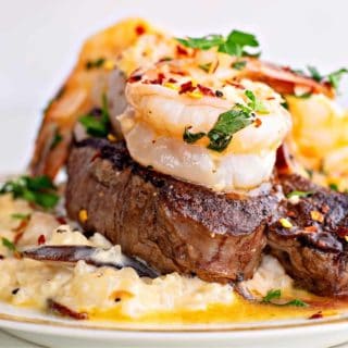a close up of surf and turf with steak and shrimp scampi on a plate