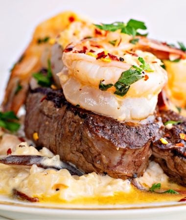 a close up of surf and turf with steak and shrimp scampi on a plate