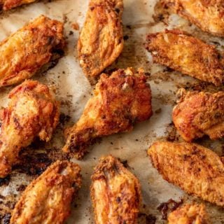crispy baked chicken wings on a parchment lined baking sheet