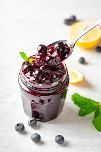 One jar of Keto Blueberry Sauce with a spoon